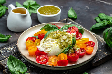 Salad burrata cheese tomatoes and green pesto. Delicious balanced food concept. superfood concept. Healthy, clean eating. Vegan or gluten free diet. top view
