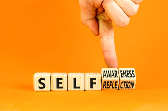 Self reflection awareness symbol. Concept words Self reflection and self awareness on cubes. Beautiful orange background. Psychologist hand. Psychological self reflection awareness concept. Copy space