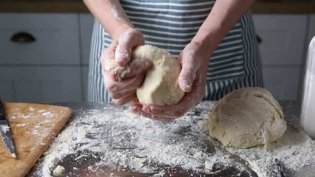 Unrecognizable baker kneading dough in hands cooking food