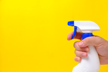 Sprayer for cleaning and washing windows, plumbing in hand yellow background.