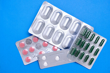 Lot of pills in package blue background. Concept shortage and rise in price medicines.