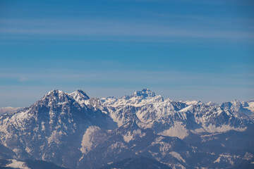Fototapeta na wymiar Scenic view on snow capped mountain peaks of Karawanks in Carinthia (Kaernten), Austria. Julian Alps. Winter wonderland in Austrian Alps, Europe. View from Freiberg on Hochstuhl (Stol), Triglav, Kepa