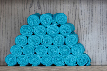 A Pile of rolled-up blue towels, can be used for towel, fitness centers, gym, or spa