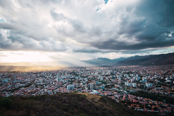 Areal view of the city of Cochabamba, Bolivia with cloudy skys and rays of sunlight. Located in South America
