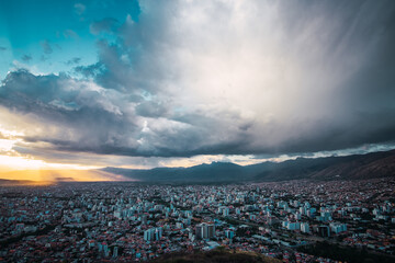 Areal view of the city of Cochabamba, Bolivia with cloudy skys and rays of sunlight. Located in South America