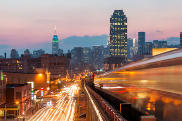 Fototapeta na wymiar New York view at sunset with blurred metro train, busy roads and Manhattan skyline