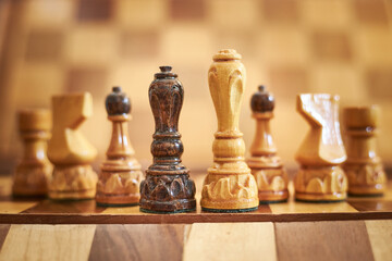 Pieces of chess on a chessboard, natural light, bright wooden material