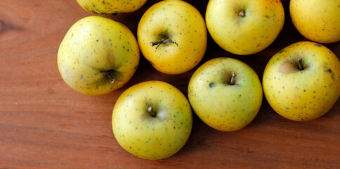 yellow and green apples on a wooden table, apple harvest in october in autumn