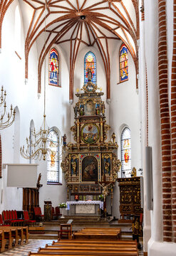 Main nave and presbytery of St. John Evangelist church Kosciol Sw. Jana Ewangelisty in historic old town center of Bartoszyce in Poland