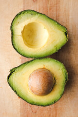 Close-up photo of a cut avocado on a wooden board.