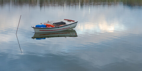 A small boat tied by a rope in the lagoon