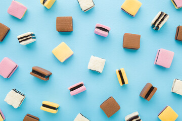 Colorful jelly gummy candies on light blue table background. Pastel color. Sweet snack pattern....