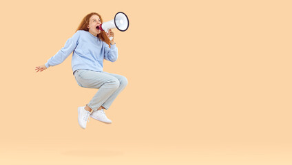 Fototapeta na wymiar Breaking news. Funny teenage girl jumps and shouts into loudspeaker making important and interesting announcement. Young woman with megaphone levitates near copy space on beige background. Web banner.