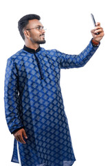 Happy handsome indian man wearing traditional outfit holding or using mobile phone celebrating diwali festival and giving expression