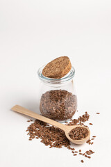 Macro photo of raw flax seeds in glass jar on white background for Superfood and diet product concept