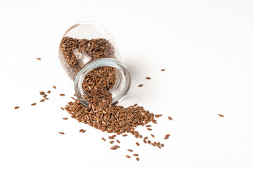 Macro photo of raw flax seeds in glass jar on white background for Superfood and diet product concept