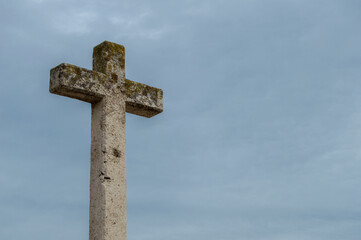 A lone stone cross silhouetted against a sky
