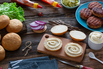  process of cooking delicious burgers with grilled meat cutlets, various sauces and vegetables