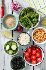 ingredients of vegetable salad with quinoa, cottage cheese and olive oil. The process of preparing a delicious vegetarian fresh vegetable salad with quinoa and cottage cheese