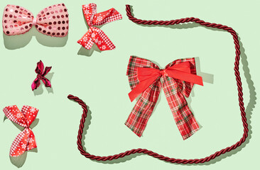 Various holiday bows on green pastel background
