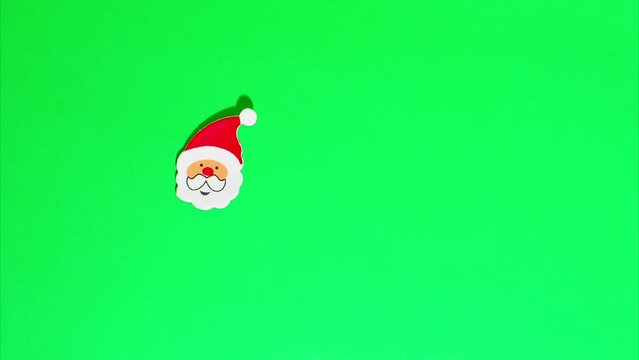 Christmas stop motion animation, funny santa claus in a red hat, white beard and mustache move on a green chroma key background