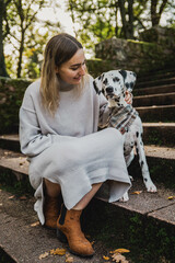 Junge Frau mit jungen Dalmatiner (Junghund / Welpe) während Herbstausflug auf Treppe