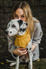 junger Dalmatiner Hund (Welpe / Junghund) mit gelben Halstuch im Herbst und junger hübscher Frau