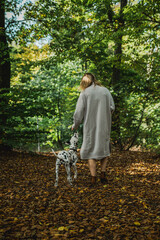 Junge Frau mit Dalmatiner Junghund / Welpe im Herbst spazieren