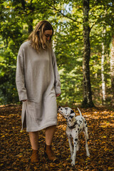 Junge Frau mit Dalmatiner Junghund / Welpe im Herbst spazieren