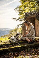 junge Frau in grauen Kleid possiert mit jungen Dalmatiner (Welpe / Jundhund) vor Ruine