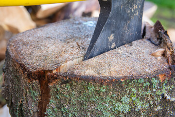 An ax and a stump while chopping firewood on a clear day. Heating.