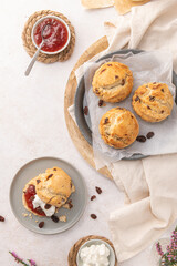 Homemade raisin scones with clotted cream and strawberry jam ready to eat