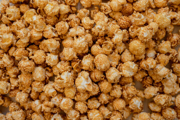 Caramel popcorn background, top view