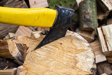 An ax and a stump while chopping firewood on a clear day. Heating.