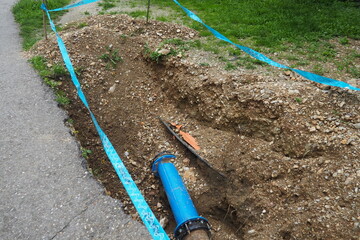 Broken ground, hole. Blue water pipes. Repair of the city water supply network. The inscription in...