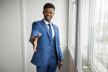 Fototapeta premium greeting of a successful man in a suit near the window