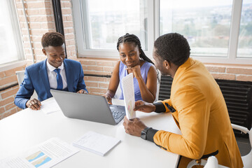 team of african successful people behind a laptop	