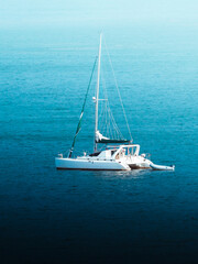 Single boat sailing away from old of san juan puerto rico with the amazing deep blues of the ocean
