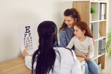 Mother and child have appointment at modern ophthalmologist's office. Mom and little kid see doctor...