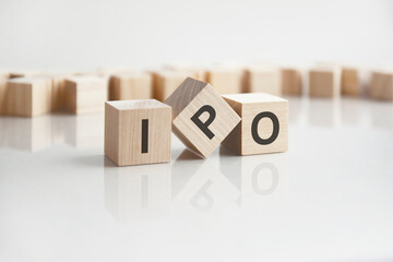 text IPO on wooden blocks with letters on a white background. reflection of the caption on the mirrored surface of the table