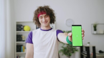 Smiling man sports fan showing smartphone with pre-keyed screen, sports bets