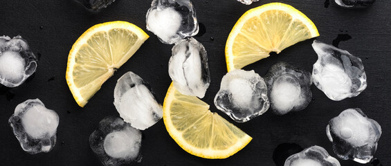 Panoramic photo with lemon slices and natural ice on a dark background. top view
