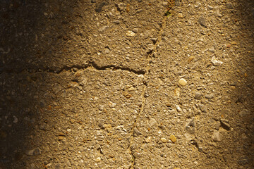The texture of the asphalt pavement interspersed with stones