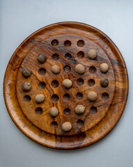 Wooden peg solitaire, Solo Noble or simply Solitaire, a board game for one player involving movement of pegs on a board with holes