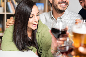 Caucasian group of friends having fun together at pub. Girl and his friends talking, laughing and enjoying their time.