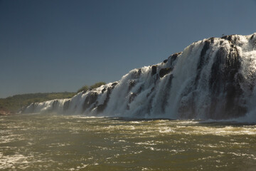 Sailing the river. The majestic Mocona waterfalls seen from the boat. The falling white water,...