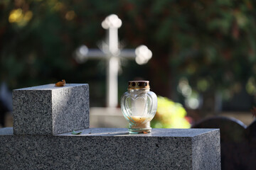 Świeczka na grobie osoby bliskiej świeci podczas święta zmarłych