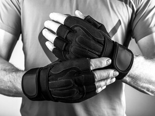Sport workout gloves close up on men hands for gym workout. Black and white photo