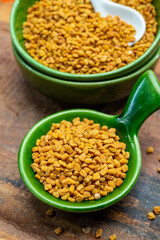 Indian spices collection, dried aromatic fenugreek seeds and another spices in clay green bowl