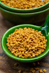 Indian spices collection, dried aromatic fenugreek seeds and another spices in clay green bowl